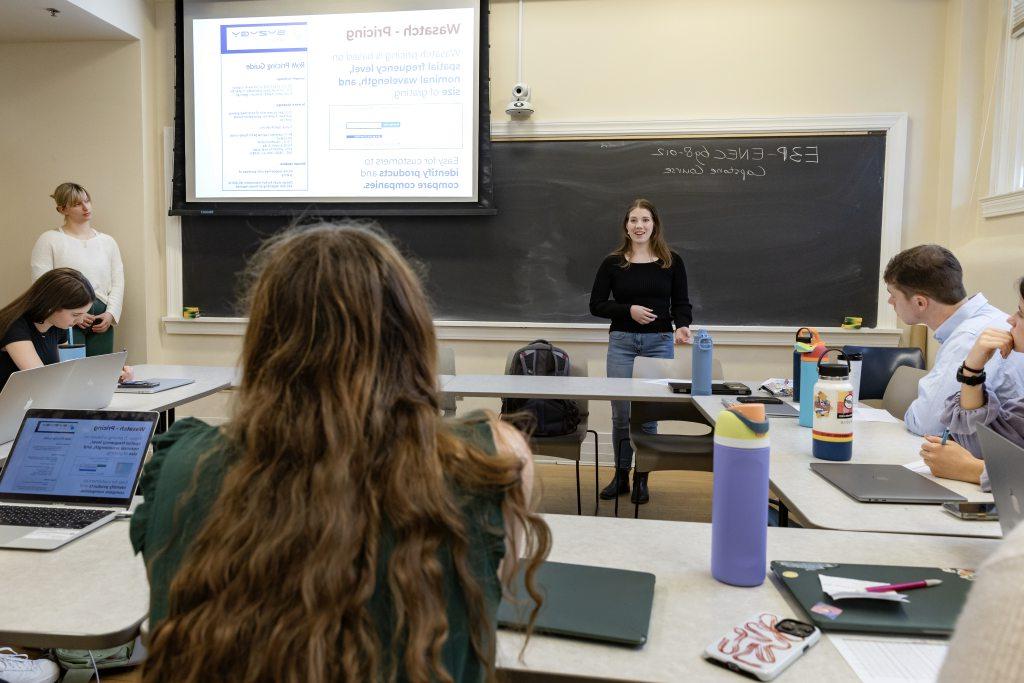 Karen Jordan standing in front of blackboard talking to class. 